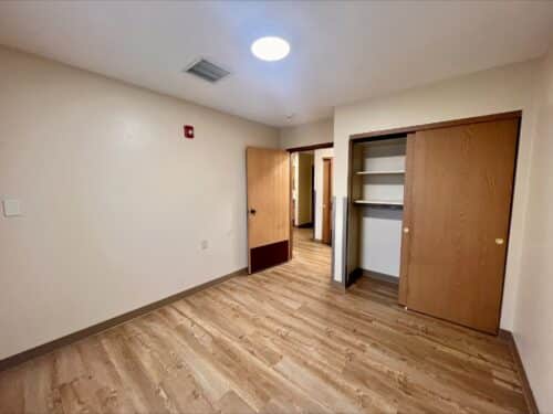 A bedroom and closet in a living space offered through affordable housing services